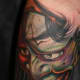 An anguished-looking green hannya tattoo.