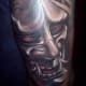 A red-eyed hannya tattoo with almost a metallic appearance.