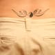 A lower-back yin yang tattoo with a winglike pattern.