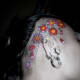 red and orange flowers behind a person's ear