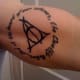 Deathly Hallows tattoo with quote: "And at the heart of our schemes, the Deathly Hallows"