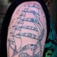 A compass can be added to a ship tattoo to symbolize direction or faith.