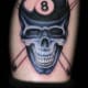 An eight ball with a skull and pool cue cross-bones.