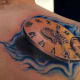 Clock tattoo with Roman numerals.
