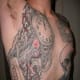 A clock incorporated into a bomb-like tattoo with wires and a digital readout.