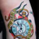 Pocket watch tattoo with the text, "Time heals nothing."