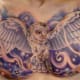 This owl is spreading its wings across someone's chest.