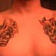 In this chest tattoo, the masks are on separate sides.