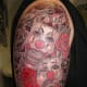 This tattoo has the masks facing forward instead of back-to-back.