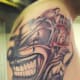 This tattoo emphasizes the black and gray, with just a touch of dark red.