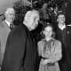 President Harry S. Truman (foreground, left) with eleven-year old Girl Scout Carol Bayerschmidt (foreground, right) in Yonkers, New York. Carol pins a red feather on the President's lapel at Larkin Plaza, in connection with the Community Chest drive