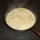 Parmesan cheese flakes are scattered over scalloped potatoes
