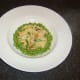 Peas are spooned around the carrot and parsnip mash