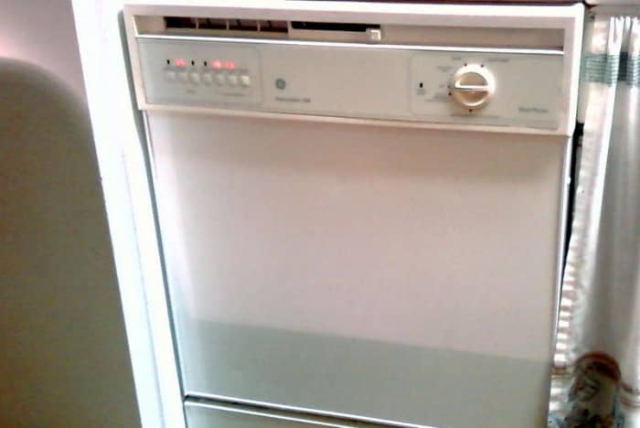 Front panel view. Your dishwasher is likely secured to the countertop with two screws at each corner above the front panel.