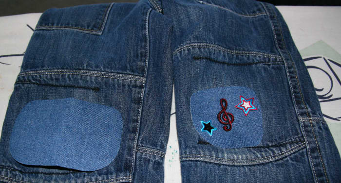 A patch is placed over the torn knee on the left. A patch (with applique) is already ironed on the right knee.