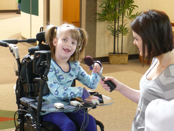  les petites boîtes grises sur le plateau de Faith sont utilisées pour conduire sa chaise électrique - ces interrupteurs interactifs sont également utilisés pour faire fonctionner un ordinateur portable qu'elle utilise à l'école. 