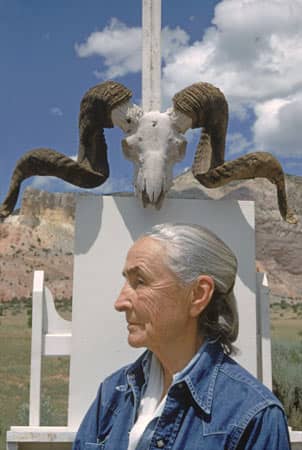 Georgia O'Keeffe in her later years, poses in front of a skull, one the items that she painted over the years.