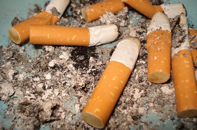 Cigarette butts in ash. An enjoyable pastime to many tobacco users, the habit is seen as anti-social and health-threatening to many non-smokers. Smoking is restricted in most developed countries nowadays, but a full ban would be a big step.