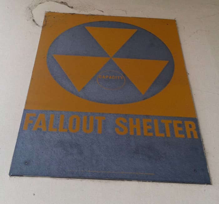 A sign indicating a fallout shelter at a government facility. Look for these signs anywhere you go so you know where they are.