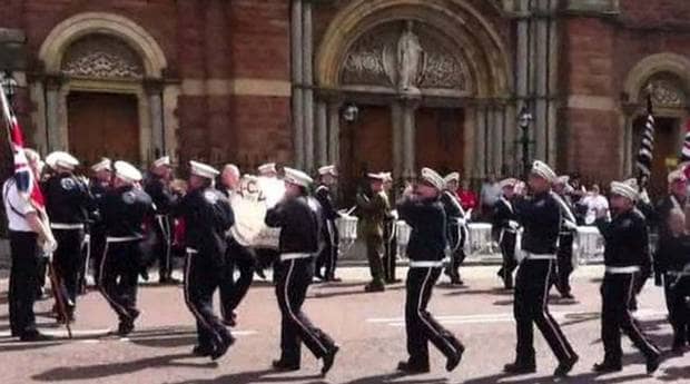 A Loyalist band marches in a circle outside St Patrick's Catholic church in Belfast on the 12th of July.