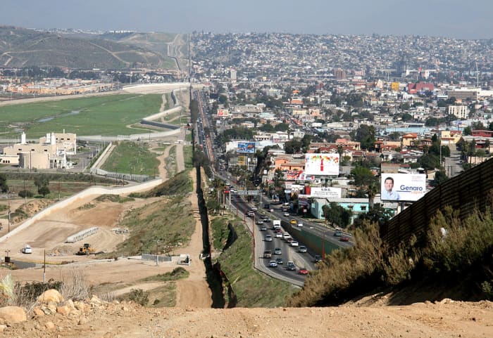 A small fence separates densely-populated Tijuana, right, from San Diego