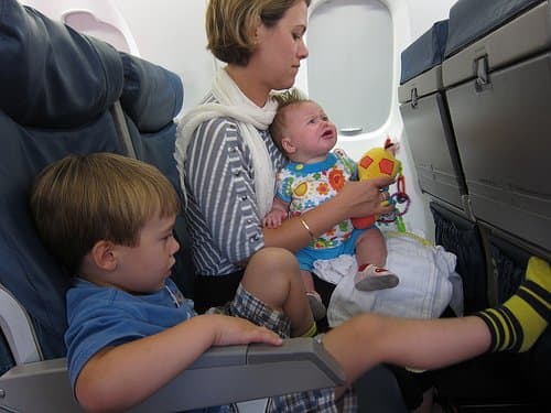 The little boy in this picture has the right idea! He has his legs extended and elevated for the flight. Mom is at an increased risk of clots as it looks like she recently had a baby.
