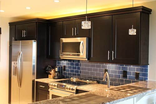 An updated backsplash, painted cabinets, lighting and new paint will totally spruce up your old kitchen.