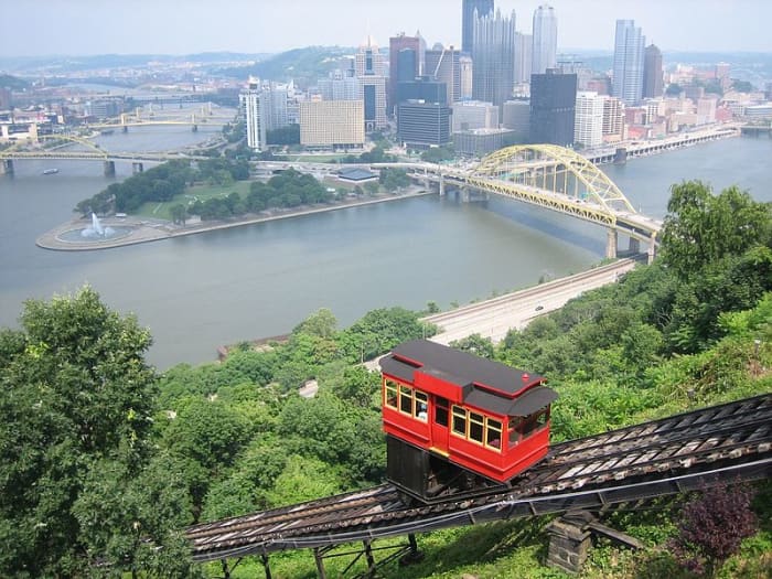 The Duquesne Incline approaches the Mount Washington Station with the downtown Pittsburgh skyline in the background.
