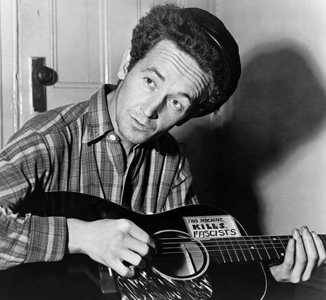 Woody Guthrie: This Machine Kills Fascists. Folk singer Woody Guthrie armed with his weapon of choice.