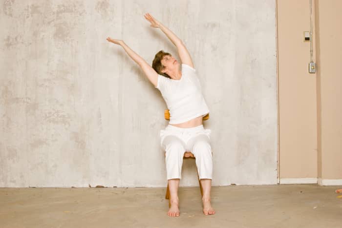 Seated Willow. As you inhale, reach up through both arms while relaxing the shoulders down. As you exhale, deepen the side stretch.