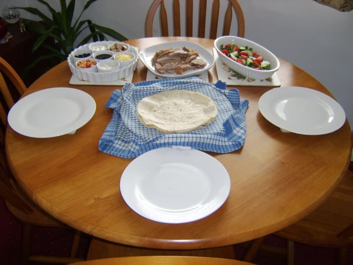 Roast turkey thigh, salad, wraps and various condiments and accompaniments are all taken to the table for everyone to help themselves.