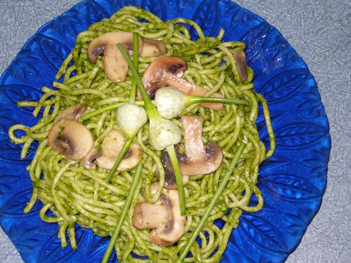 Learn how to make spinach pesto with mushrooms and garlic scapes fried in butter to top it off.