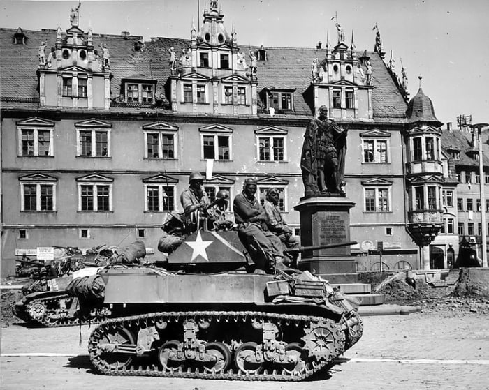 Members of Company D, 761st Tank Battalion (Black Panthers) awaiting orders in their M5 Stuart light tank to clear out German machine gun nests in Coburg, Germany. April 25, 1945.