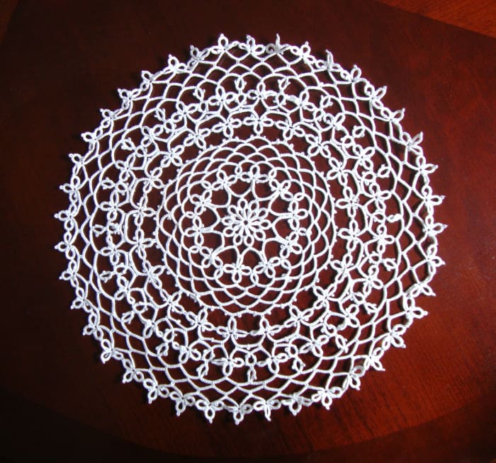 A tatted doily I found in a second-hand store. An experienced doily maker, I knew that it hadn't been done with crochet. I soon learned that this type of doily was produced through tatting. It now lives in my china cabinet.
