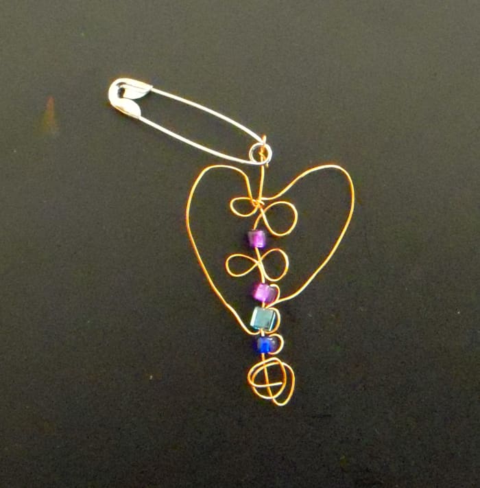 Want to make cool SWAPS? Look no further. Above: SWAP made from thin copper craft wire, a few beads, and a safety pin.