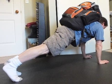 Add weight by wearing a heavy backpack. This makes push-ups more challenging and helps build muscle mass.