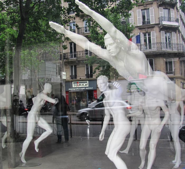 A mostly male group of mannequins cavort in their birthday suits in a Paris shop window.