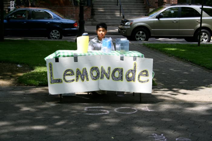 A young entrepreneur selling lemonade at a very affordable price; finding the right price is the key to success.