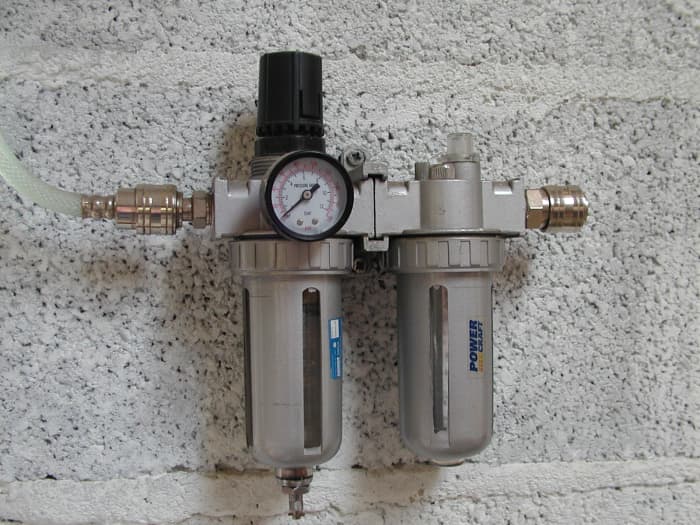 Filter, regulator, smeertoestel. Het filter heeft een automatische aftapkraan om water af te voeren wanneer de druk wordt opgeheven