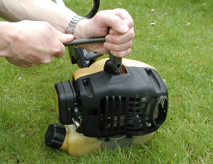 When undoing the spark plug, hold the wrench with two hands so that it doesn't slip off the plug and damage it.