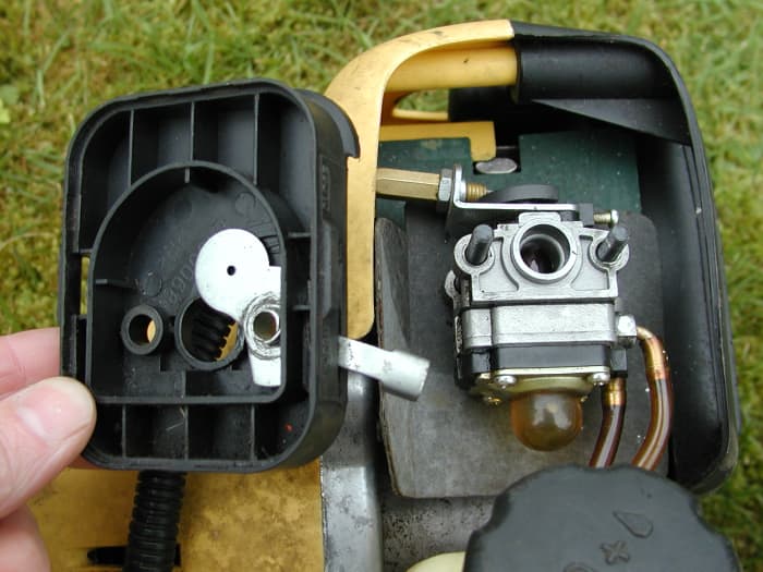 The carburetor exposed: Next, the fuel lines and throttle cable must be removed.