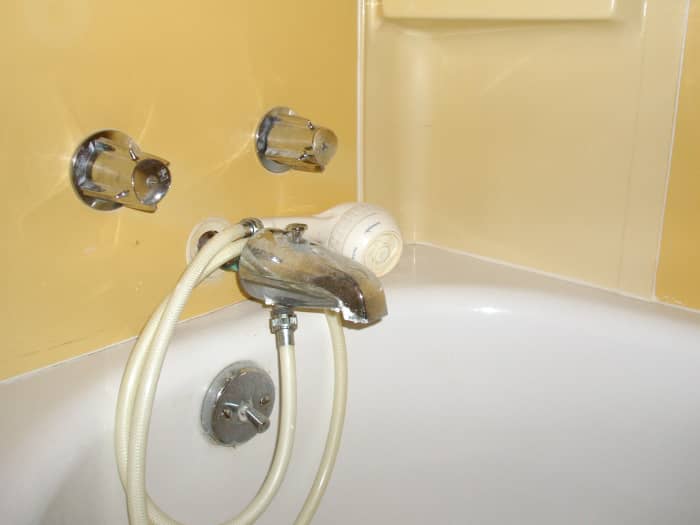 The most frustrating kind of handheld showerhead—unmounted and fed by the bath faucet rather than a pipe high in the wall.