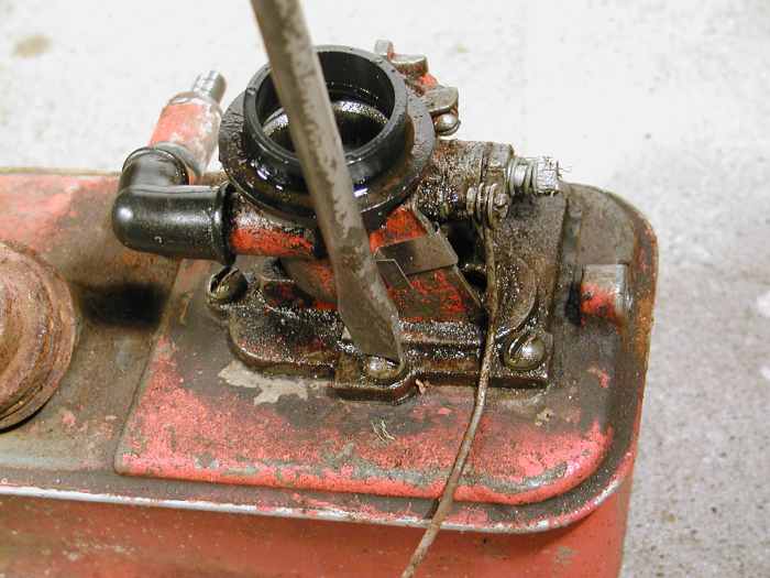 Undo the screws holding the carburetor to the the tank.