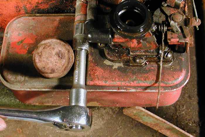 Undo the bolt holding the tank to the engine.