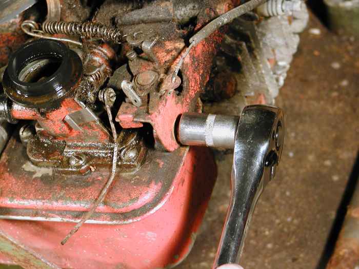 Undo the second bolt holding the tank.