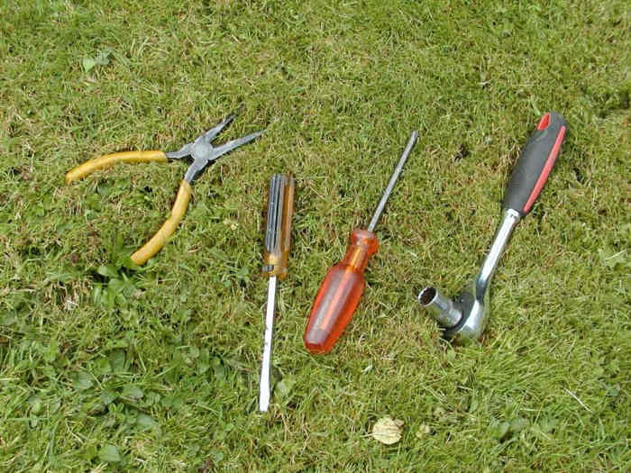 Long nose pliers, flat blade screwdriver, Philips screwdriver, and socket wrench.