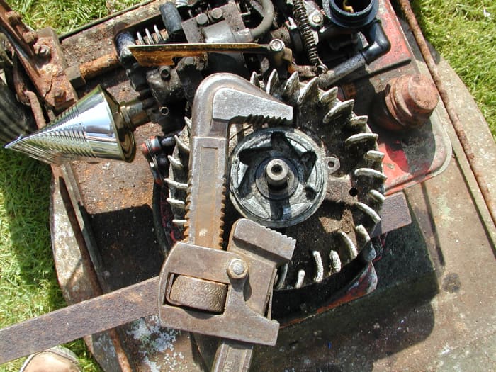 Use a pipe wrench (Stillson) to remove this piece. Keep the jaws away from the screw lugs to avoid damaging them.