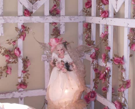 Can you believe this is a lamp? This homemade lamp was found at a local consignment shop and is the perfect accessory to a romantic cottage bedroom. The pretty fairy has a rose hat and is holding a bouquet of roses.