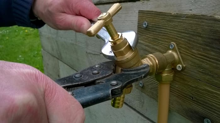 Remove the head. Ideally you should hold the body also to restrain it, otherwise if a lot of force needs to be used to loosen the head, you can end up ripping the tap off the wall.