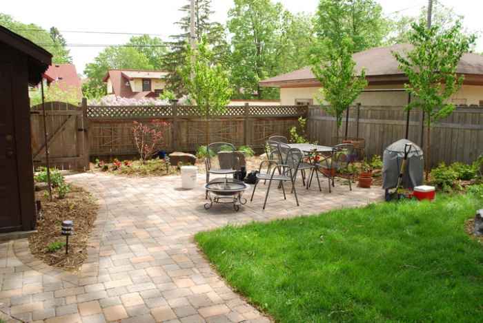 Pavers take over the backyard with a patch of green grass